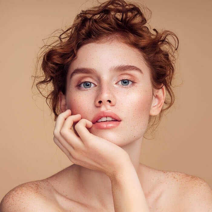 Beautiful redhead woman with her hand on her cheek