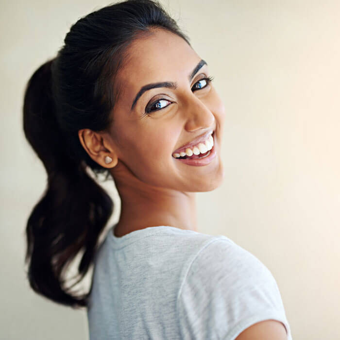 attractive and happy young woman looking back over her shoulder