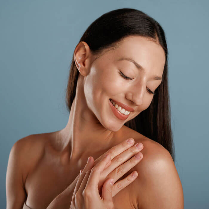young woman with clean skin smiling and looking over her shoulder